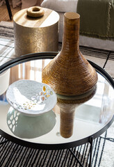 trendy coffee table decor with ceramic art and metallics 