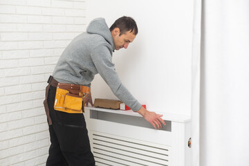 repairman using tools while installing or repairing heating radiator. plumber installing heating...