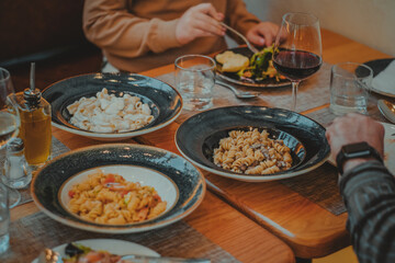 Italian restaurant table with dinner of pasta salad and a glass of wine