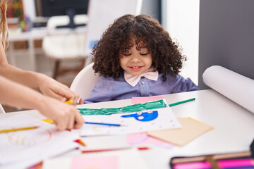 African american toddler preschool student sitting on table looking draw at kindergarten
