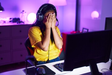 Young beautiful latin woman streamer stressed using computer at gaming room
