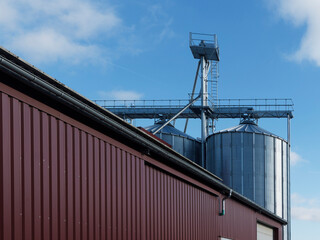 Silos agricoles ronds à fonds plats en extérieur avec grange pour stockages de céréales © Marc