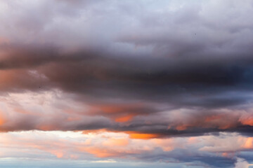 Bewitching stormy sky in the rays of the setting sun. Cloudy skies in the setting sun. A natural phenomenon