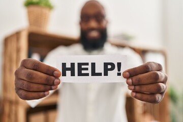 African american man holding help reminder winking looking at the camera with sexy expression,...