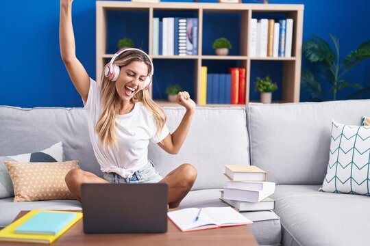 Young Blonde Woman Student Sitting On Sofa Listening To Music And Dancing At Home