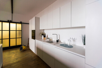 Kitchen in new luxury home with quartz waterfall island, hardwood floors, dark wood cabinets, and stainless steel appliances