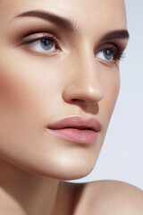 Fototapeta premium Young Caucasian girl with perfect glowing skin and natural makeup in close-up