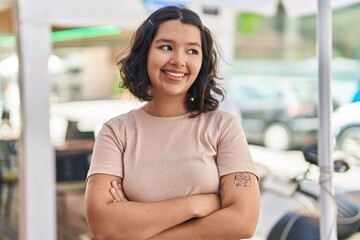 Young woman smiling confident standing with arms crossed gesture at street