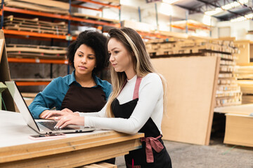 black business woman listening to explanation of female colleague at storehouse