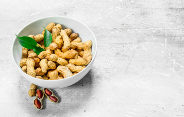 Peanuts with green leaves in the bowl .