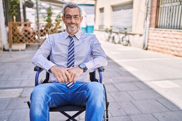 Middle age hispanic man wearing business clothes sitting on wheelchair at street