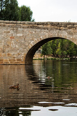 Fototapeta premium Old stone bridge and reflections on the river