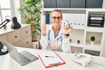 Young doctor woman wearing uniform and stethoscope screaming proud, celebrating victory and success very excited with raised arms