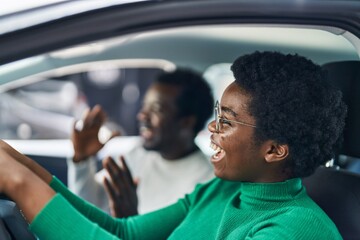 Fototapeta na wymiar African american man and woman couple driving car at street