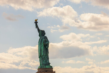 Obraz premium Close up view of Statue of Liberty against backdrop of white clouds. USA.