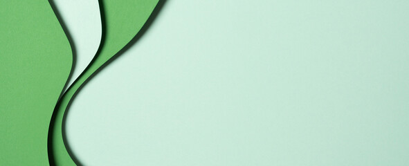 Abstract green color paper texture background. Minimal paper cut style composition with layers of geometric shapes and lines in green tone shades. Top view