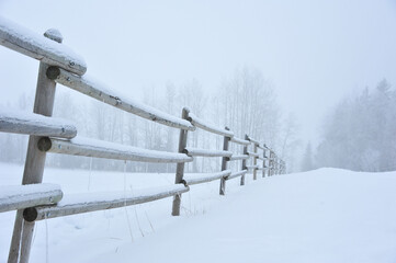 frosted snow covered wooden fence winter foggy morning country side