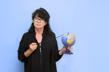 Fototapeta premium teacher points a point on the globe with a pointer