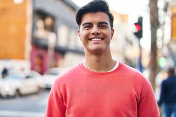 Young hispanic man smiling confident standing at street