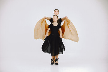 Mother and daughter ballet dancers against white background