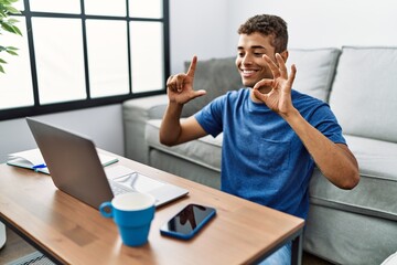 Young hispanic man gesturing sign language on video call at home
