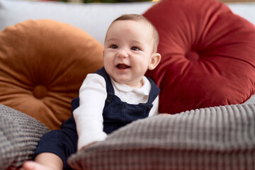 Adorable toddler smiling confident sitting on sofa at home