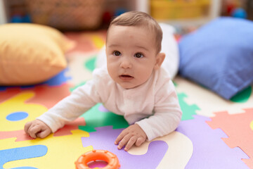 Adorable toddler lying on floor at kindergarten