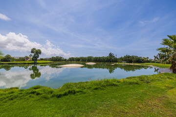 Beautiful view of blue pond water surface on blue sky with rear white clouds background. Aruba.