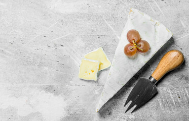 Brie cheese with grapes and knife.