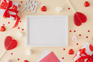 Valentines day concept. Flat lay photo of red gift boxes, heart shaped lollipops and candies, inscription love you on beige background with white frame in the middle. Lovers holiday card idea.