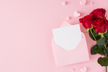 Women day concept. Flat lay photo of red flowers, envelope with letter and pink heart shaped...