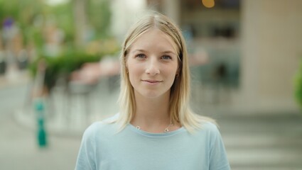 Fototapeta premium Young blonde woman smiling confident standing at street
