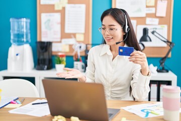 Young chinese woman working at the office doing online shopping celebrating achievement with happy smile and winner expression with raised hand