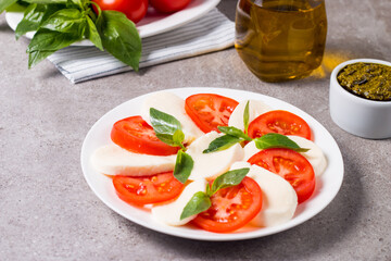 Close-up photo of caprese salad with ripe tomatoes, basil, buffalo mozzarella cheese. Italian and Mediterranean food concept. Fresh and healthy organic meal. Starter and antipasti. 