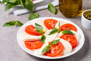 Close-up photo of caprese salad with ripe tomatoes, basil, buffalo mozzarella cheese. Italian and Mediterranean food concept. Fresh and healthy organic meal. Starter and antipasti. 