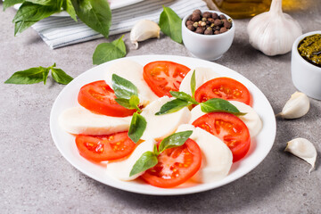 Close-up photo of caprese salad with ripe tomatoes, basil, buffalo mozzarella cheese. Italian and Mediterranean food concept. Fresh and healthy organic meal. Starter and antipasti. 
