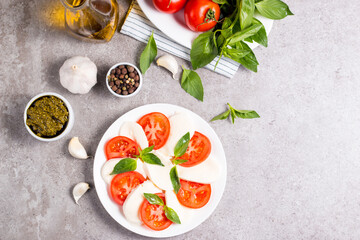 Close-up photo of caprese salad with ripe tomatoes, basil, buffalo mozzarella cheese. Italian and Mediterranean food concept. Fresh and healthy organic meal. Starter and antipasti. 