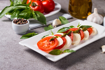 Close-up photo of caprese salad with ripe tomatoes, basil, buffalo mozzarella cheese. Italian and Mediterranean food concept. Fresh and healthy organic meal. Starter and antipasti. 