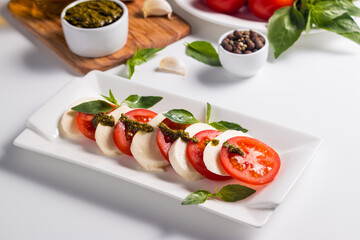 Close-up photo of caprese salad with ripe tomatoes, basil, buffalo mozzarella cheese. Italian and Mediterranean food concept. Fresh and healthy organic meal. Starter and antipasti. 