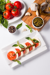 Close-up photo of caprese salad with ripe tomatoes, basil, buffalo mozzarella cheese. Italian and Mediterranean food concept. Fresh and healthy organic meal. Starter and antipasti. 