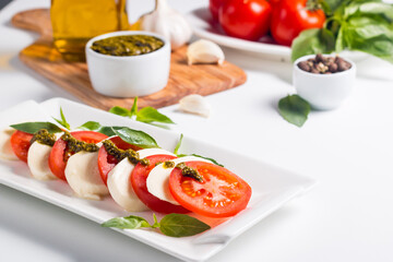 Close-up photo of caprese salad with ripe tomatoes, basil, buffalo mozzarella cheese. Italian and Mediterranean food concept. Fresh and healthy organic meal. Starter and antipasti. 