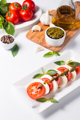 Close-up photo of caprese salad with ripe tomatoes, basil, buffalo mozzarella cheese. Italian and Mediterranean food concept. Fresh and healthy organic meal. Starter and antipasti. 