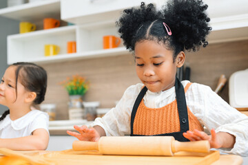 children making a bread in kitchen. Kids learning kitchen skill