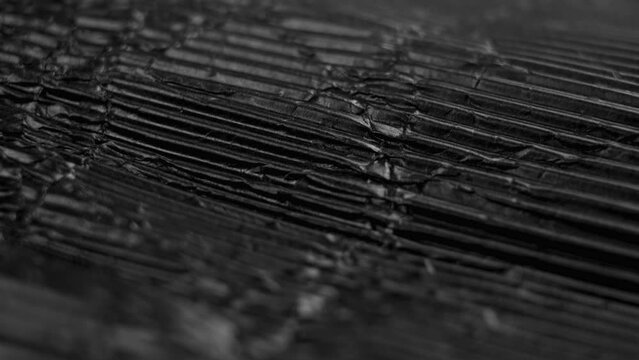 Monochrome black ribbed paper texture. Old ragged wrinkled rough cardboard. Rotation