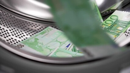 European one hundred euro banknotes falling into the washing machine. Money laundering financial concept