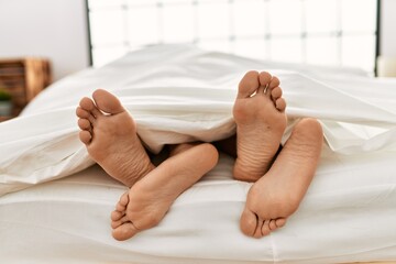 Two hispanic men couple lying on bed at bedroom