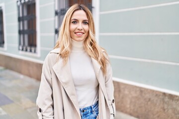 Fototapeta premium Young blonde woman smiling confident standing at street