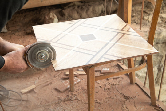 Worker Cutting A Ceramic Tile With A Grinder.