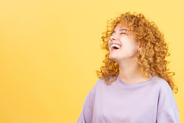 Woman with curly hair and casual clothes laughing