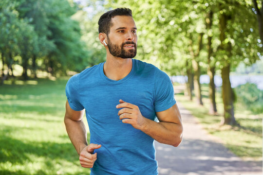 Male runner in park during sunny day in spring or summer
